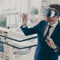 Young businessman wearing virtual reality goggles working in office